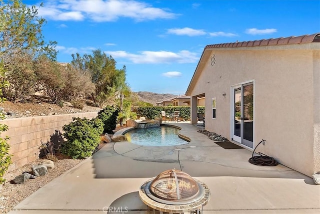 view of swimming pool with a mountain view, a patio, and an outdoor fire pit