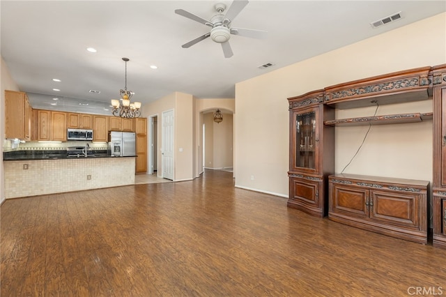 unfurnished living room featuring dark hardwood / wood-style floors, sink, and ceiling fan with notable chandelier