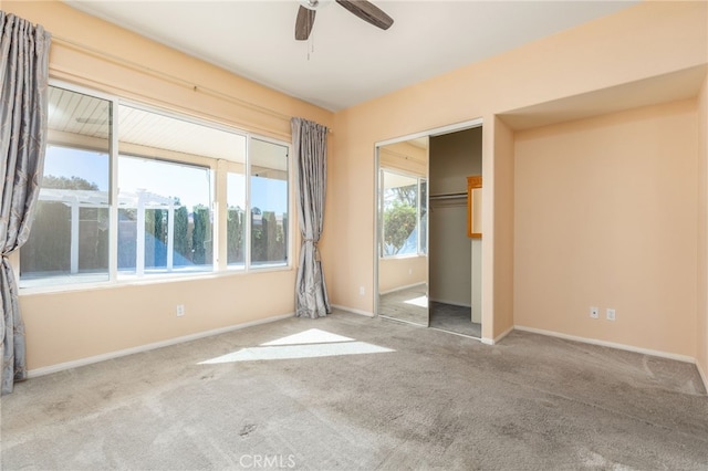 unfurnished bedroom with ceiling fan, multiple windows, and a closet