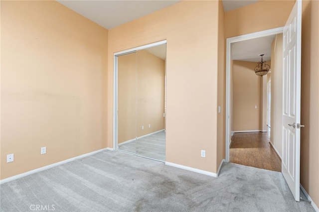 unfurnished bedroom featuring a closet and light colored carpet