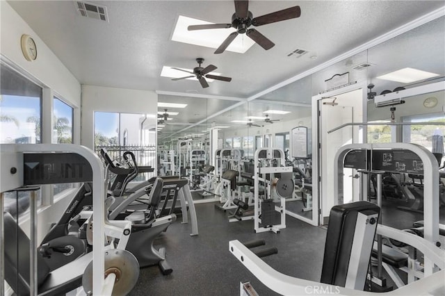 gym featuring ceiling fan and a textured ceiling