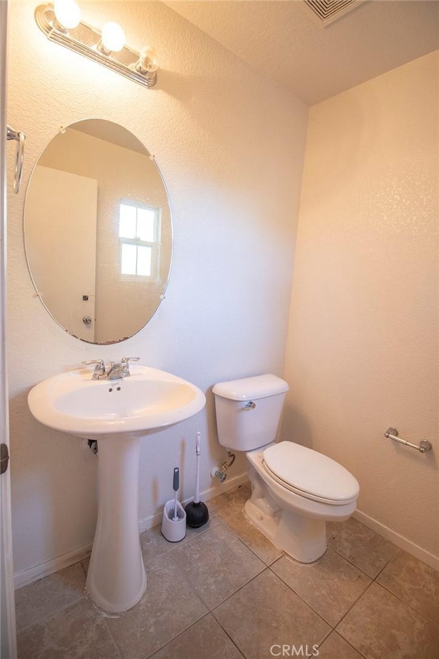 bathroom featuring tile patterned flooring and toilet