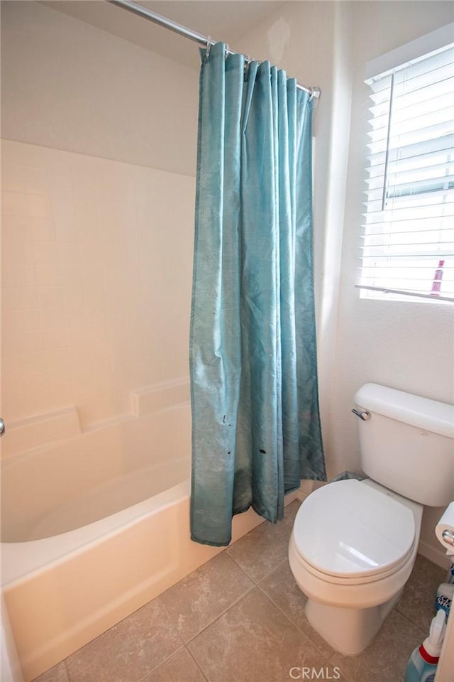 bathroom with tile patterned flooring, shower / bath combination with curtain, and toilet