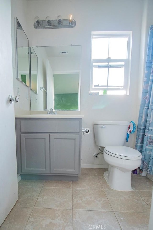 bathroom with tile patterned flooring, vanity, and toilet