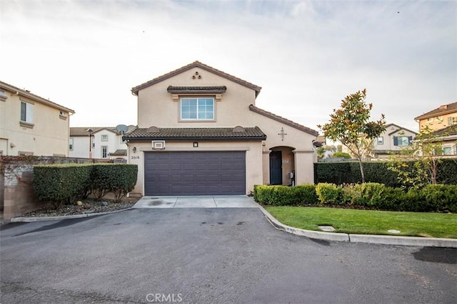 mediterranean / spanish house with a garage and a front yard