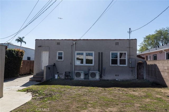 back of property with ac unit, fence, and stucco siding