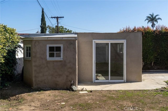 back of property featuring stucco siding