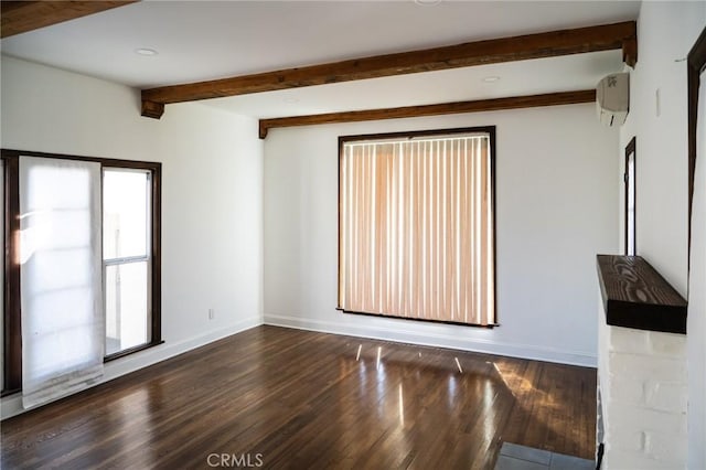 unfurnished room with beam ceiling, a wall mounted AC, baseboards, and wood finished floors