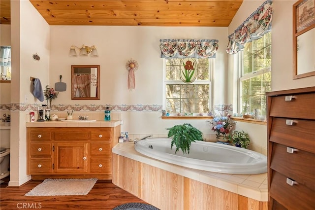 bathroom with wooden ceiling, tiled bath, vaulted ceiling, vanity, and hardwood / wood-style flooring