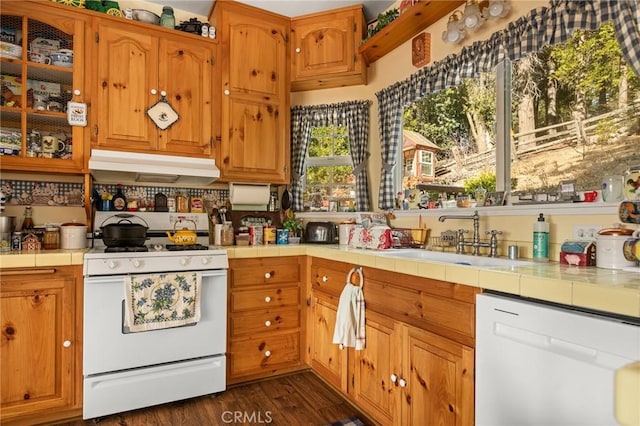 kitchen featuring white appliances, tile counters, dark wood-type flooring, and sink