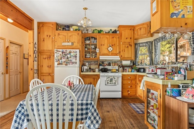 kitchen with decorative light fixtures, dark hardwood / wood-style flooring, white appliances, and an inviting chandelier