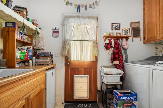 clothes washing area with cabinets, separate washer and dryer, and sink