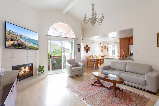 living room featuring beamed ceiling, light hardwood / wood-style floors, and a wealth of natural light