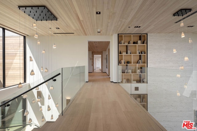 corridor with light hardwood / wood-style flooring and wood ceiling