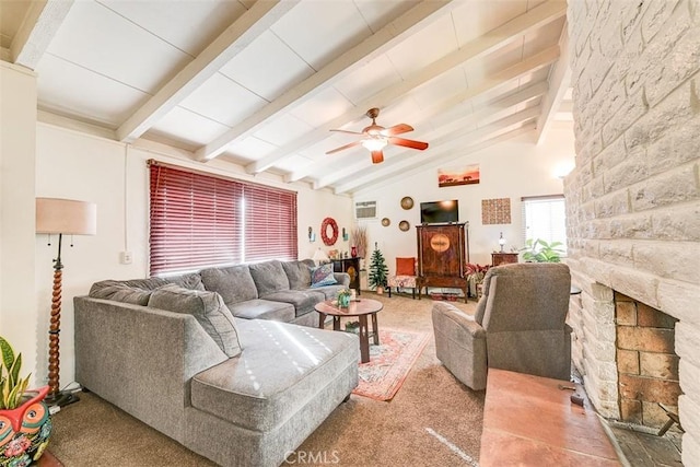 living room featuring carpet flooring, a stone fireplace, ceiling fan, and lofted ceiling with beams