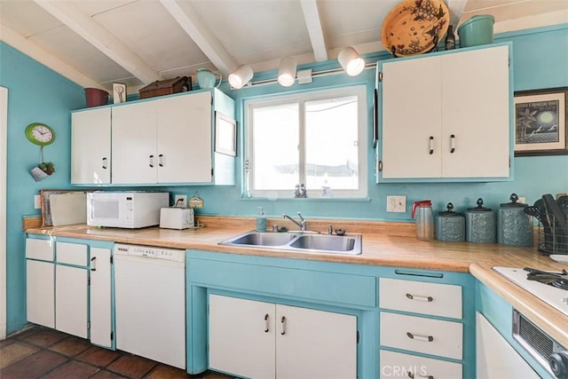 kitchen with beamed ceiling, white appliances, white cabinetry, and sink