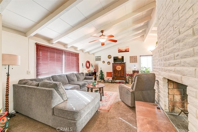 living room with ceiling fan, lofted ceiling with beams, a stone fireplace, and carpet floors