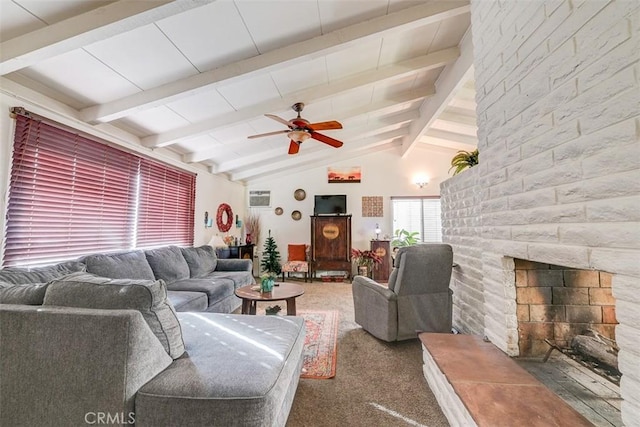 living room featuring dark colored carpet, vaulted ceiling with beams, a large fireplace, and ceiling fan