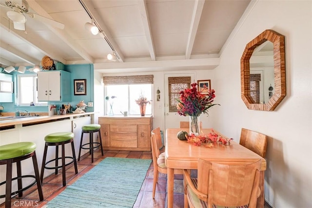 dining space with beamed ceiling, ceiling fan, and track lighting