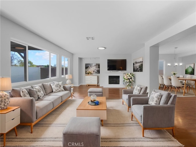 living room featuring a chandelier and light wood-type flooring