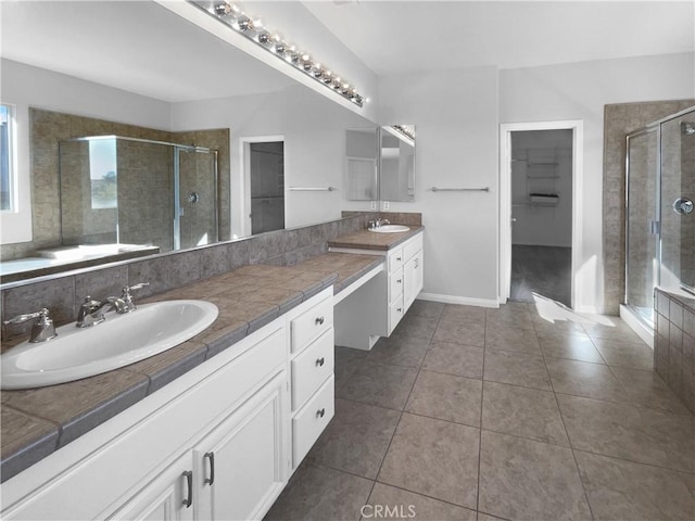 bathroom featuring a spacious closet, a stall shower, tile patterned floors, and vanity