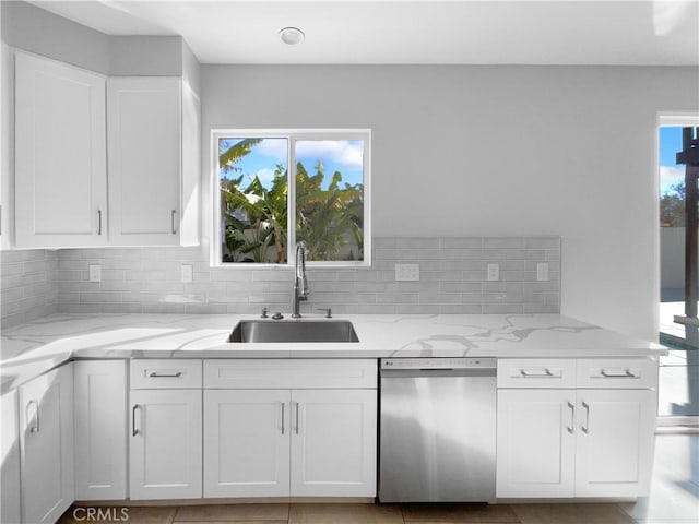 kitchen with white cabinetry, dishwasher, sink, and light stone counters