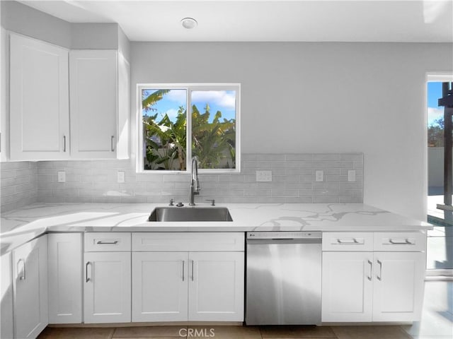 kitchen with dishwasher, white cabinets, a sink, and a wealth of natural light