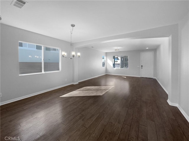 unfurnished room featuring dark hardwood / wood-style floors and an inviting chandelier