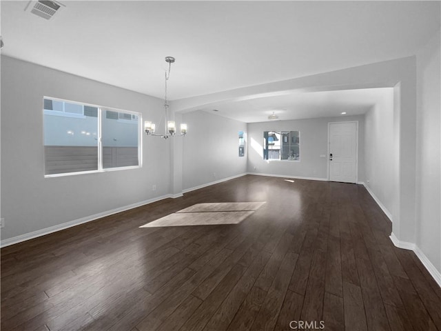 interior space featuring wood finished floors, baseboards, a chandelier, and visible vents