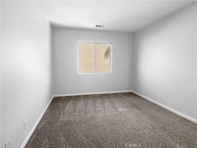carpeted empty room featuring baseboards and visible vents