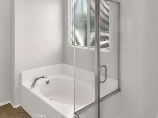 bathroom with tile patterned floors and tiled tub