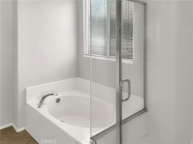 bathroom featuring a garden tub, baseboards, and tile patterned floors