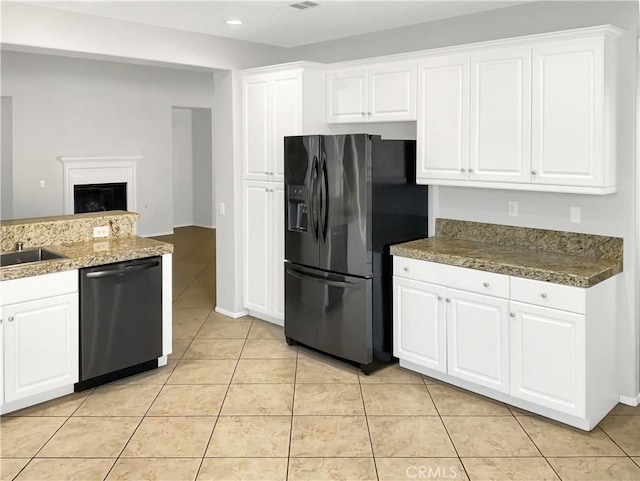 kitchen featuring stainless steel dishwasher, black fridge with ice dispenser, light tile patterned floors, and white cabinets