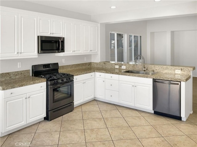 kitchen with stainless steel appliances, white cabinets, a sink, and a peninsula