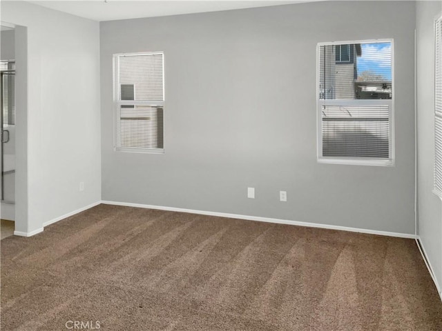 unfurnished room with carpet floors and baseboards
