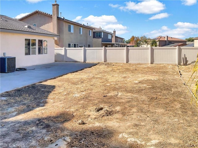 view of yard featuring a patio area, a fenced backyard, and central air condition unit