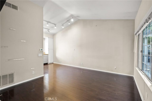 empty room featuring dark hardwood / wood-style floors and vaulted ceiling