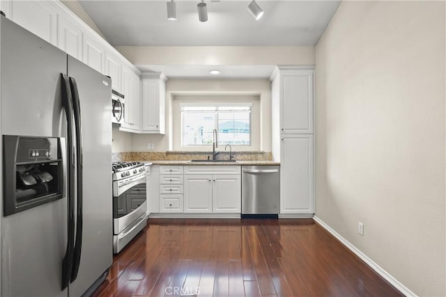 kitchen with sink, stainless steel appliances, light stone counters, dark hardwood / wood-style floors, and white cabinets