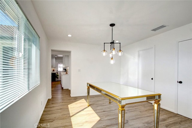 dining area featuring light hardwood / wood-style floors and a chandelier