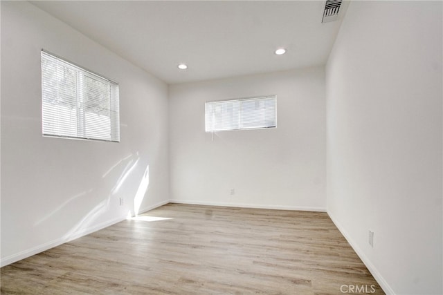 empty room featuring a healthy amount of sunlight and light hardwood / wood-style floors