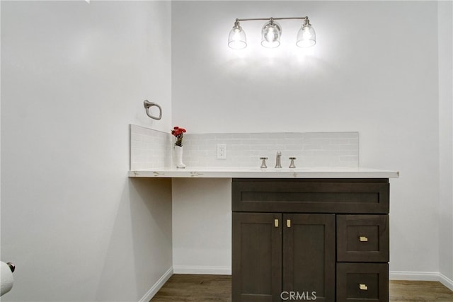 bathroom featuring hardwood / wood-style floors, backsplash, and sink