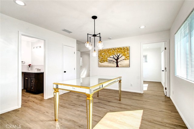 dining room with plenty of natural light, light wood-type flooring, and sink