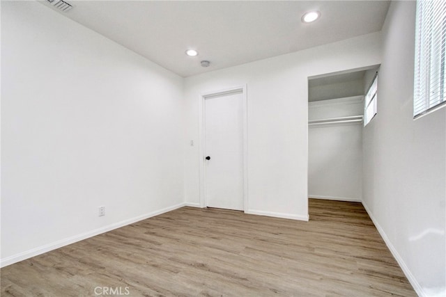 unfurnished bedroom featuring light hardwood / wood-style flooring and a closet