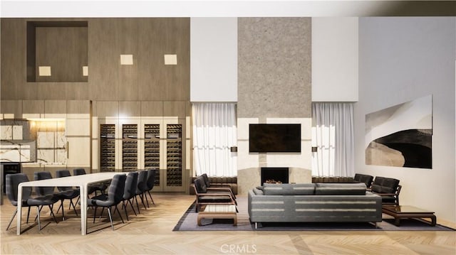 living room featuring a fireplace, a high ceiling, and light parquet floors