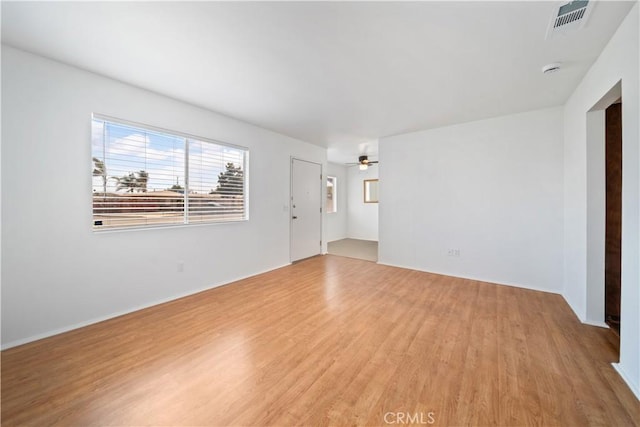 spare room with ceiling fan and light wood-type flooring