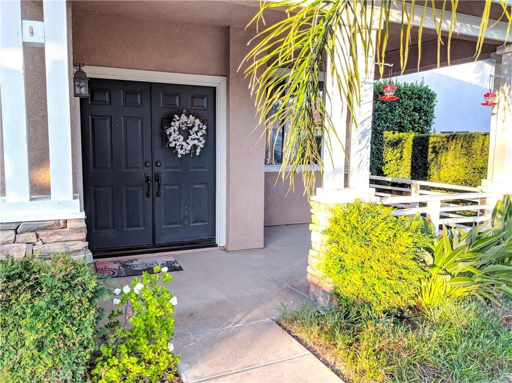 doorway to property featuring stucco siding