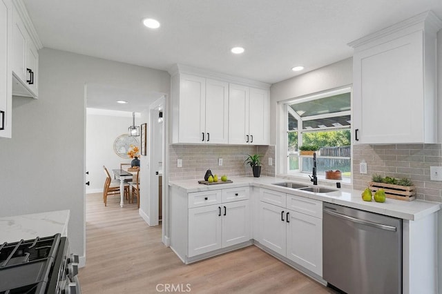 kitchen with light hardwood / wood-style floors, white cabinetry, sink, and appliances with stainless steel finishes