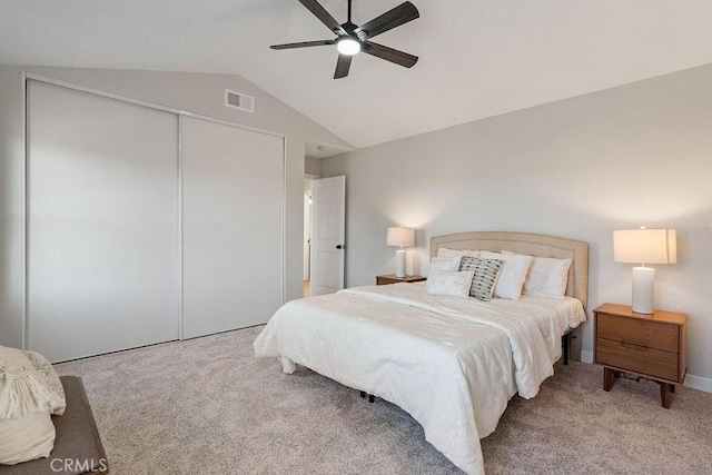 carpeted bedroom featuring ceiling fan, lofted ceiling, and a closet