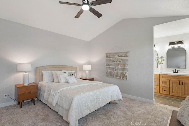 bedroom featuring light carpet, ensuite bathroom, ceiling fan, sink, and lofted ceiling