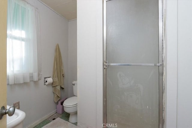 bathroom with a shower with door, tile patterned flooring, and toilet